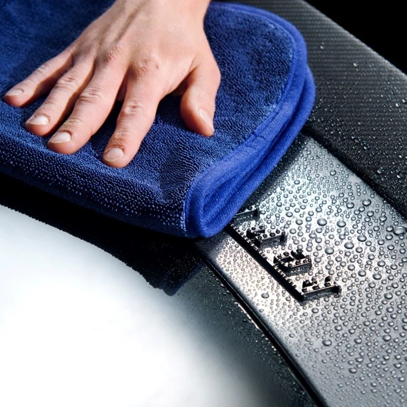 Gyeon Q²M Silk Dryer Evo en action sur une surface de voiture, absorbant l'eau efficacement